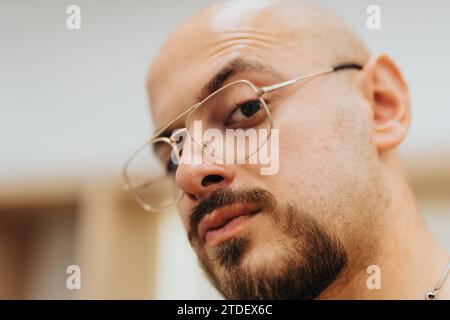 Porträt eines Glatzen-Mannes, der eine Brille trägt und in die Kamera blickt. Kopfschuss. Stockfoto