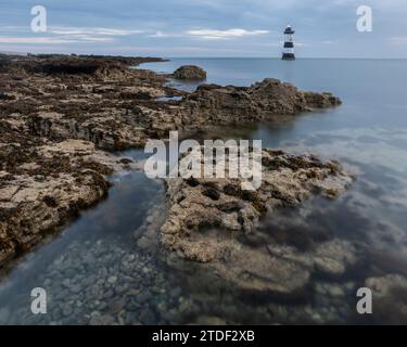 Rocks and Trwyn du Lighthouse at Dawn, Penmon Point, Anglesey, Wales, Vereinigtes Königreich, Europa Stockfoto