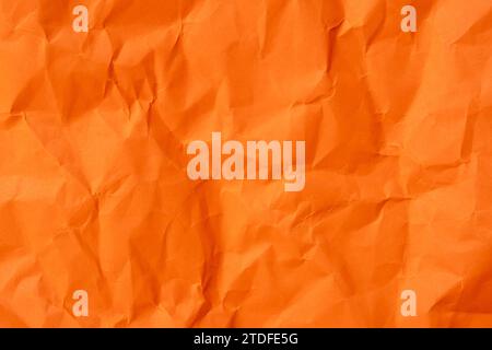 Die orange zerknitterte Papierstruktur wird für die Papierhintergrundstruktur in dekorativen Kunstwerken verwendet. Stockfoto