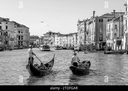 Zwei Gondoliere überqueren den berühmten Canal Grande in Venedig, Italien, in Schwarz-weiß Stockfoto