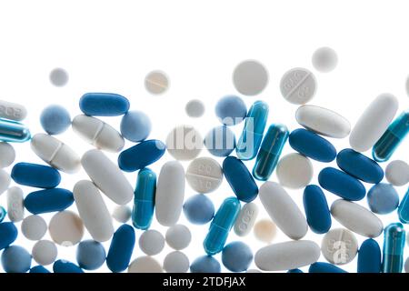 Blaue und weiße Pillen und Tabletten vor weißem Hintergrund Stockfoto