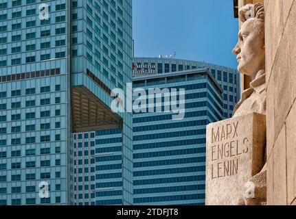 Ironischer Blick auf kommunistische Vergangenheit und kapitalistische Gegenwart: Statue des heldenhaften Arbeiters im Kulturpalast und in modernen Wolkenkratzern in Warschau, Polen Stockfoto