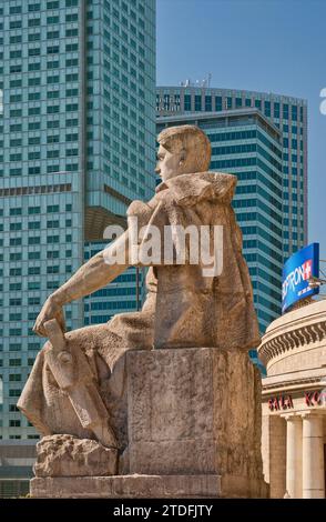 Ironischer Blick auf kommunistische Vergangenheit und kapitalistische Gegenwart: Statue des heldenhaften Arbeiters im Kulturpalast und in modernen Wolkenkratzern in Warschau, Polen Stockfoto