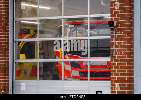Feuerwehrauto und ein Krankenwagen in der Garage. Mäntsälä, Finnland. November 2023. Stockfoto