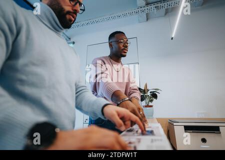 Fachleute in Geschäftskleidung diskutieren und verhandeln einen Vertrag. Ein Immobilienmakler erklärt einem potenziellen Käufer Rechtsdokumente. Sie befinden sich in einem Stockfoto
