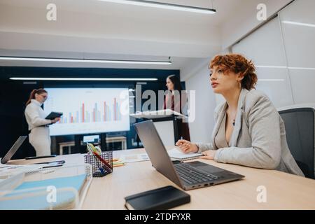 Verschiedene Geschäftsleute nehmen an einer Vorlesung Teil, diskutieren Statistiken und arbeiten gemeinsam an der strategischen Planung und Gewinnsteigerung. Stockfoto