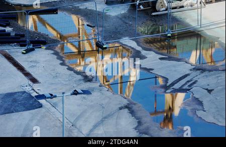 Holzrahmenbau spiegelt sich in einer großen Pfütze wider Stockfoto