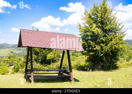 Geschützte Picknickbank auf dem Land an einem Sommertag Stockfoto