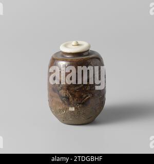 Teekaddy mit goldenbrauner Glasur, anonym, anonym, ca. 1775 - ca. 1799 Schmutzstange oder Chare van Steengoed mit elfenbeinfarbenem Deckel, teilweise mit goldbrauner Glasur bedeckt. Der untere Teil des Busses ist unglasiert. Altes Etikett auf der Innenseite mit 'Lait Bizen/ am Ende des 18. Jahrhunderts'. BIBEN. Japanisches Steingut. Glasur. Deksel: elfenbeinverglasung Staubstab oder Chare van Steengoed mit elfenbeinfarbenem Deckel, teilweise mit einer goldbraunen Glasur bedeckt. Der untere Teil des Busses ist unglasiert. Altes Etikett auf der Innenseite mit 'Lait Bizen/ am Ende des 18. Jahrhunderts'. BIBEN. Japanisches Steingut. Glasur. Deksel: elfenbein Vitrif Stockfoto