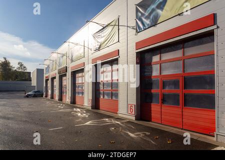 Gebäude mit einer Werkstatt für Nutzfahrzeuge mit sechs Garagentoren. Moderne Garage mit automatischen Toren für LKW und große Autos. Außenansicht... Stockfoto