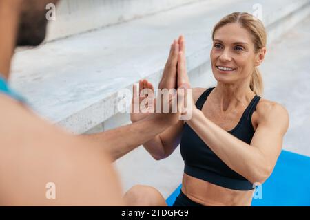 Zwei Freunde, Mann und Frau, die zusammen arbeiten und draußen ein paar Crunches machen. Stockfoto