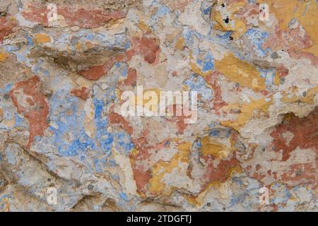Abstrakt, Detail, Muster eines Abschnitts mehrfarbiger abblätternder Farbschichten auf einer alten Steinaußenwand einer Residenz in Jerusalem, Israel. Stockfoto