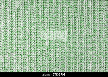 Jersey Textil Hintergrund, grün weiß meliert gestrickter Wollstoff. Strickwaren aus Wolle, Pullover, Oberflächenbeschaffenheit des Pullovers, Textilstruktur, Stoffsurf Stockfoto