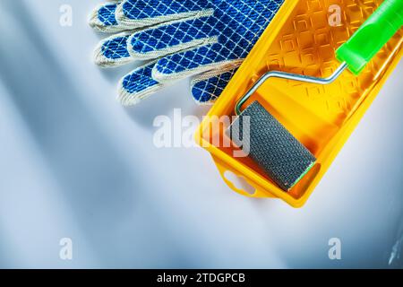 Paar Schutzhandschuhe Malerwalze auf weißem Hintergrund Stockfoto