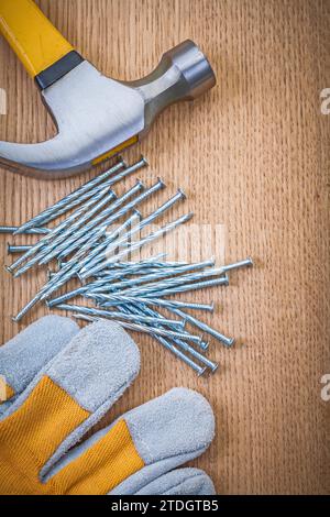 Die Zusammensetzung von Klauenhammernägeln und Schutzhandschuhen auf Holzbrettern Stockfoto