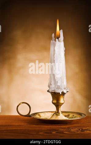 Kopieren Sie das Bild einer brennenden Kerze in einen alten Kerzenhalter Stockfoto