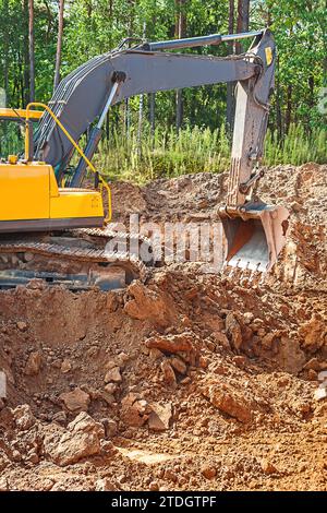 Bagger zum Ausheben von Lehmboden auf einer Baustelle im Wald Stockfoto