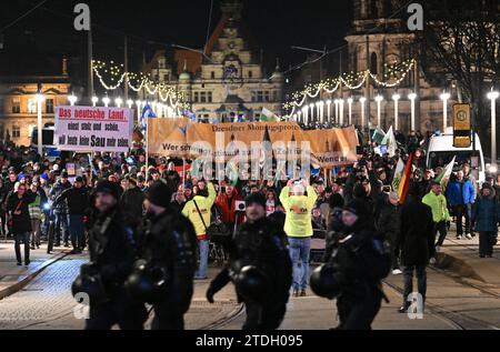 Dresden, Deutschland. Dezember 2023. Teilnehmer einer Demonstration der rechtsextremen Bewegung Pegida gehen über die Augustusbrücke. Robert Michael/dpa/Alamy Live News Stockfoto