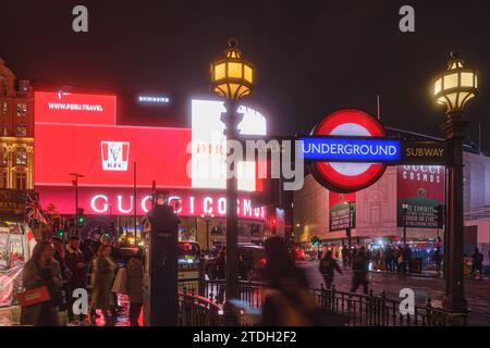 London, Großbritannien - 16. November 2023: Unterirdischer Eingang am Piccadilly Circus bei Nacht, mit beleuchteten Reklametafeln im Hintergrund. Stockfoto