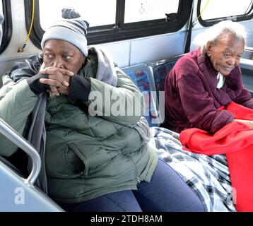 Racine, Wisconsin, USA. Dezember 2023. Die Bewohner des Parkview Manor Wohnhauses in Racine, Wisconsin, darunter JOANN MARQUETTE, Linke und ihre Tante MYRIA JOHNSON, suchen sich in einem Stadtbus Schutz vor der Kälte, nachdem ein Feuer am Montag Morgen des 18. Dezember 2023 in einem Teil des Komplexes wütete. (Kreditbild: © Mark Hertzberg/ZUMA Press Wire) NUR REDAKTIONELLE VERWENDUNG! Nicht für kommerzielle ZWECKE! Stockfoto