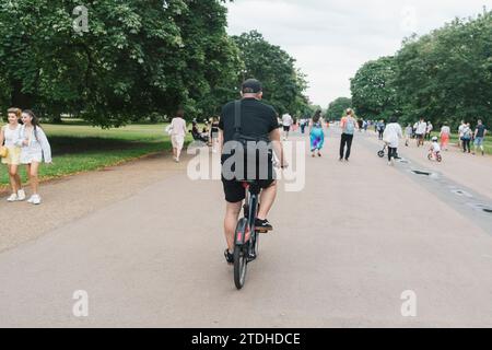 Ein Mann fährt mit einem Leihfahrrad/Verleih-Santander eBike in London durch einen Park Stockfoto