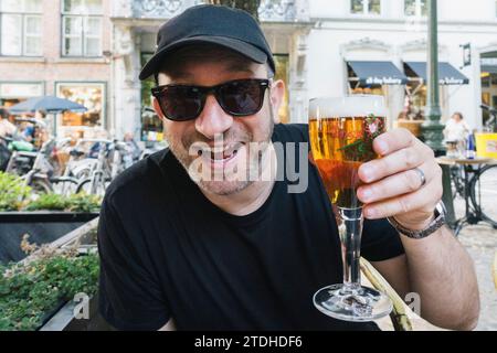 Ein Mann hält Gläser Bier und ist aufgeregt und durstig Stockfoto