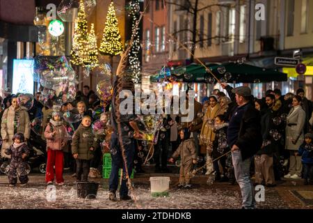 Vorweihnachtszeit, Straßenkünstler, die große Seifenblasen kreieren, in Schadow-Arkaden, im Stadtzentrum von Düsseldorf, NRW, Deutschland, Stockfoto