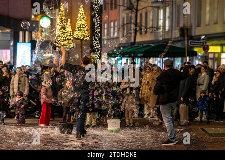 Vorweihnachtszeit, Straßenkünstler, die große Seifenblasen kreieren, in Schadow-Arkaden, im Stadtzentrum von Düsseldorf, NRW, Deutschland, Stockfoto