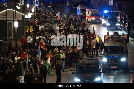 Dresden, Deutschland. Dezember 2023. Teilnehmer einer Demonstration der rechtsextremen Bewegung Pegida laufen abends am Terrassenufer entlang. Robert Michael/dpa/Alamy Live News Stockfoto