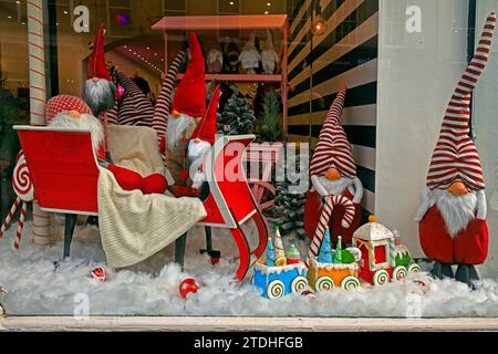 Amüsante Schaufensterpräsentation mit Weihnachtsmotiv und Zwergen und Schlitten. Dezember 2023. Stockfoto