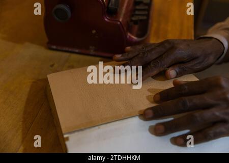 Brailleschrift-Lesesitzung: Die Finger eines Blinden auf seinem Buch, um eine Passage zu lesen. Stockfoto