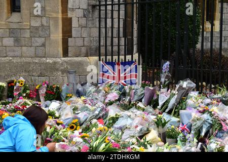 Eine große Menge Blumen vor einer britischen Flagge, die am Tor vor Windsor Castle angebracht ist, zum Gedenken an Königin Elisabeth II Stockfoto