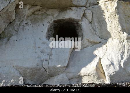 Höhleneingang mit Kletterseil und ausgegrabenen Schritten in den weißen Kreidefelsen am Strand am Fuße der White Cliffs of Dover Stockfoto