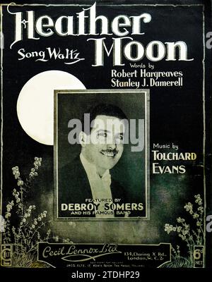 Notencover für Heather Moon, ein Liedwalzer mit Worten von Robert Hargreaves und Stanley J. Damerell und Musik von Tolchard Evans, herausgegeben von Cecil Lennox Ltd., London, um 1930 Das Cover zeigt ein Porträt des Bandleader Debroy Somers, dessen berühmtes Orchester das Stück aufführte. Das Mondlicht-Heidekraut-Design spiegelt den romantischen Stil der populären Musik der Zwischenkriegszeit und die Bedeutung von Tanzbands bei der Förderung von Liedern durch Live-Auftritte, Radio und Aufnahmen wider. Stockfoto