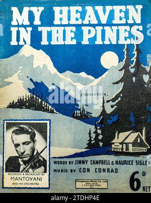 Cover von My Heaven in the Pines, ein beliebtes Lied mit Worten von Jimmy Campbell und Maurice Sigler und Musik von Con Conrad. Veröffentlicht von Cinephonic Music Co. Ltd., London, Preis 6 Tage netto. Das illustrierte Cover von F. Robertson zeigt eine Berglandschaft mit Kiefern, einem Cottage und mondbeleuchtetem Himmel. Ein Foto zeigt Mantovani, der das Lied mit seinem Orchester aufnahm und ausstrahlte. Diese Ausgabe spiegelt die britische Popmusik der 1930er Jahre und ihre Verbindungen zur Tanzbandkultur wider. Stockfoto