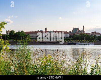 Warschau, Masowien, Polen - 10. Juli 2023: Blick auf das Königsschloss Warschau und die Altstadt vom gegenüberliegenden Ufer der Weichsel. Am Frühen Abend. Stockfoto