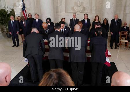 Polizeibeamte des Obersten Gerichtshofs der Vereinigten Staaten legen am Montag, 18. Dezember 2023, den Sarg des pensionierten Obersten Gerichtshofs Sandra Day OConnor auf die Lincoln Catafalque, vor einem Privatdienst in der Großen Halle des Obersten Gerichtshofs in Washington. Von links sehen wir den Obersten Richter der Vereinigten Staaten John G. Roberts, Jr., Associate Justices des Obersten Gerichtshofs Clarence Thomas, Samuel Alito, Sonia Sotomayor Elena Kagan, Neil Gorsuch, Brett Kavanaugh, Amy Coney Barrett, Ketanji Brown Jackson und den ehemaligen Associate Justice des Obersten Gerichtshofs Anthony M. Kennedy. Richter O Connor, ein AR Stockfoto