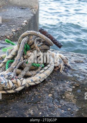 Platz zum Anbringen eines kleinen Bootes. Befestigungen zum Binden der Festmacherleine. Befestigungspunkt. Kleiner Poller auf dem Pier. Segelkonzept für Boote Stockfoto