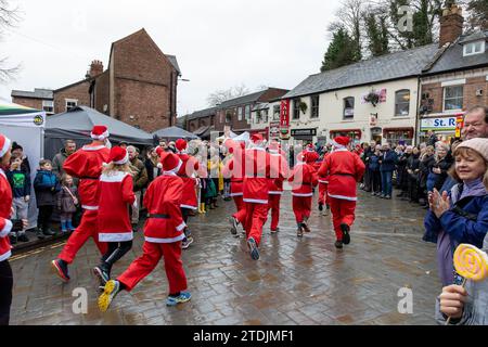 Der Santa Dash von 2023 lief beim Dickensian Day Festival durch das Dorf Lymm in Cheshire Stockfoto