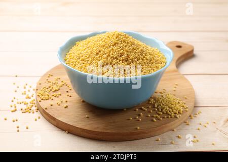 Hirsegrieß in der Schüssel auf hellem Holztisch Stockfoto