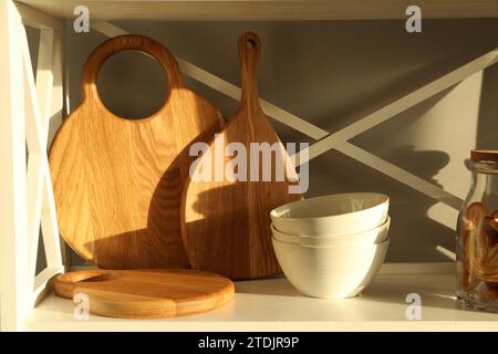 Schneidebretter aus Holz, Schüsseln und Kekse auf dem Regal Stockfoto