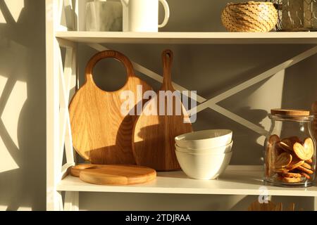 Schneidebretter aus Holz, Geschirr, Küchenutensilien und französische palmier-Kekse auf dem Regal Stockfoto