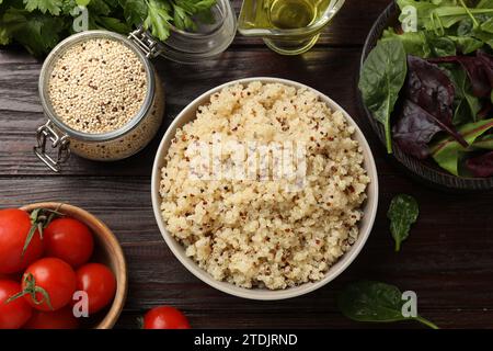 Leckerer Quinoa-Brei in Schüssel, Gemüse und Samen auf Holztisch, flach gelegt Stockfoto