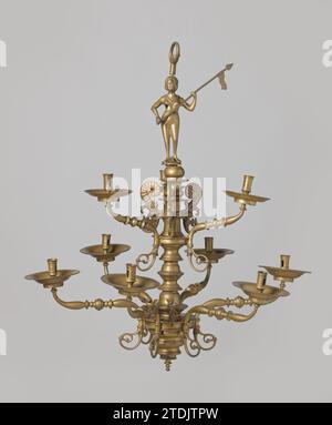 Dekorative Elemente einer Kerzenkrone in zwei Höhen in Form von Voluten und Engeln, 1525 - 1575 drei volutenförmige dekorative Elemente mit einem Nodus in der Mitte. Unten enden die Voluten in einem Rangmotiv. Die Elemente sind mit einer, zwei oder ohne dreieckige Markierungen nummeriert. Das nicht markierte Stück unterscheidet sich leicht in der Farbe und kann später hinzugefügt werden. Zwei dekorative Elemente in Form von Engeln sitzen auf einer Kugel, eines von ihnen schlägt auf eine Trompete. Unter der Kugel ein Gewinde, mit dem die Elemente am unteren Armring befestigt werden können. Der Engel mit der Trompete ist bequem mit drei Triangl Stockfoto