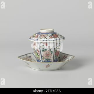 Sechseckiger, bedeckter Becher und Untertasse mit Blumensprays, Vögeln und Insekten, anonym, ca. 1725 - ca. 1749 hoher, sechseckiger Deckelkopf und Porzellanschale, auf der Glasur in blau, rot, rosa, grün, gelb, schwarz und Gold. Auf der Ebene der Schale eine Blumenrosette in einem Medaillon; rund sechs Gänge mit blühenden Pflanzen (einschließlich Lotus, Chrysantheme, Pfingstrose) mit Vogel oder Insekten; der Rücken mit sechsmal einem Blütenzweig. Kopf und Deckel mit derselben Dekoration. Famle Rose. Porzellan. Glasur. Gold (Metall) Malerei / Vergoldung / Verglasung hoher, sechseckiger Deckelkopf und Schale aus Porzellan, bemalt Stockfoto