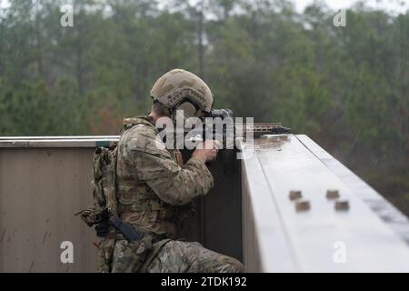 Ein Green Barett der US Army, das der 7. Special Forces Group (Airborne) zugeordnet ist, nimmt am Roten Imperium-Schießwettbewerb 2023 auf Camp „Bull“ Simons, Florida, am 1. Dezember 2023 Teil. Die Veranstaltung stellt die Fähigkeit des Fahrers heraus, erfolgreich eine Meile zu laufen und ein mehrstöckiges städtisches Schießhaus zu infiltrieren und dabei bewegte Ziele aus verschiedenen Positionen zu eliminieren. (Foto der US-Armee von PFC. Stefano Dabdoub-Olivera) Stockfoto