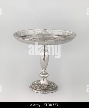 Tazza, zum Gedenken an das Relief von Bergen op Zoom, anonym, um 1625 Trinkwaage am Fuße von getriebenem Silber. In der Mitte die vergoldete Waffe von Bergen op Zoom, die von zwei wilden Männern gehalten wird. Über der Waffe eine Banderolle mit Inschrift. Gemüse und Kartuschen am Fuß. Bergen op Zoom Silber (Metall). Vergoldung (Material) Vergoldung Bergen op Zoom Trinkskala am Fuß aus getriebenem Silber. In der Mitte die vergoldete Waffe von Bergen op Zoom, die von zwei wilden Männern gehalten wird. Über der Waffe eine Banderolle mit Inschrift. Gemüse und Kartuschen am Fuß. Bergen op Zoom Silber (Metall). Gildi Stockfoto