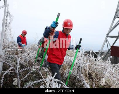 Peking, Chinas Provinz Hunan. Dezember 2023. Mitarbeiter des lokalen Stromversorgungsunternehmens patrouillieren am 18. Dezember 2023 die Stromleitung in der Gemeinde Qingshuiping in Xiangxi Tujia und der Autonomen Präfektur Miao in der zentralen chinesischen Provinz Hunan. Es wurden Gegenmaßnahmen ergriffen, um die Auswirkungen von starkem Schneefall und anderen Frostbedingungen zu verhindern oder zu mildern. Quelle: Yu Caihua/Xinhua/Alamy Live News Stockfoto