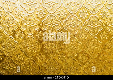 Schöne goldene gelbe Glasdekoration mit asiatischem Stil geprägtem Texturmuster für traditionellen Vintage Tempelarchitektur Hintergrund Stockfoto