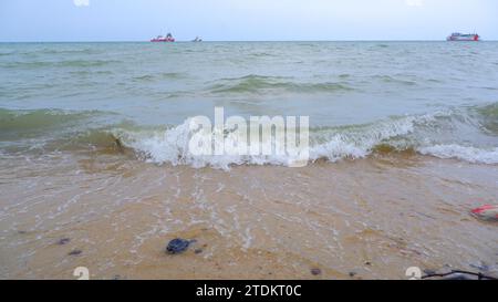 Natürlicher Blick Auf Rolling Tidal Waves Vor Der Kulisse Mehrerer Tanker Am Tanjung Kalian Beach, Indonesien Stockfoto